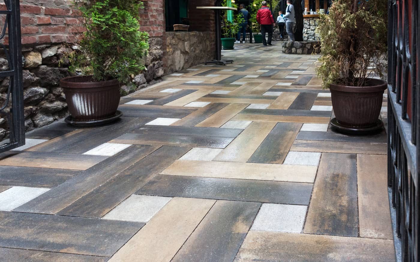 Bašta restorana sa saksijama popločana izduženim behaton pločama u više boja sa belim kockama, model Ambient Line