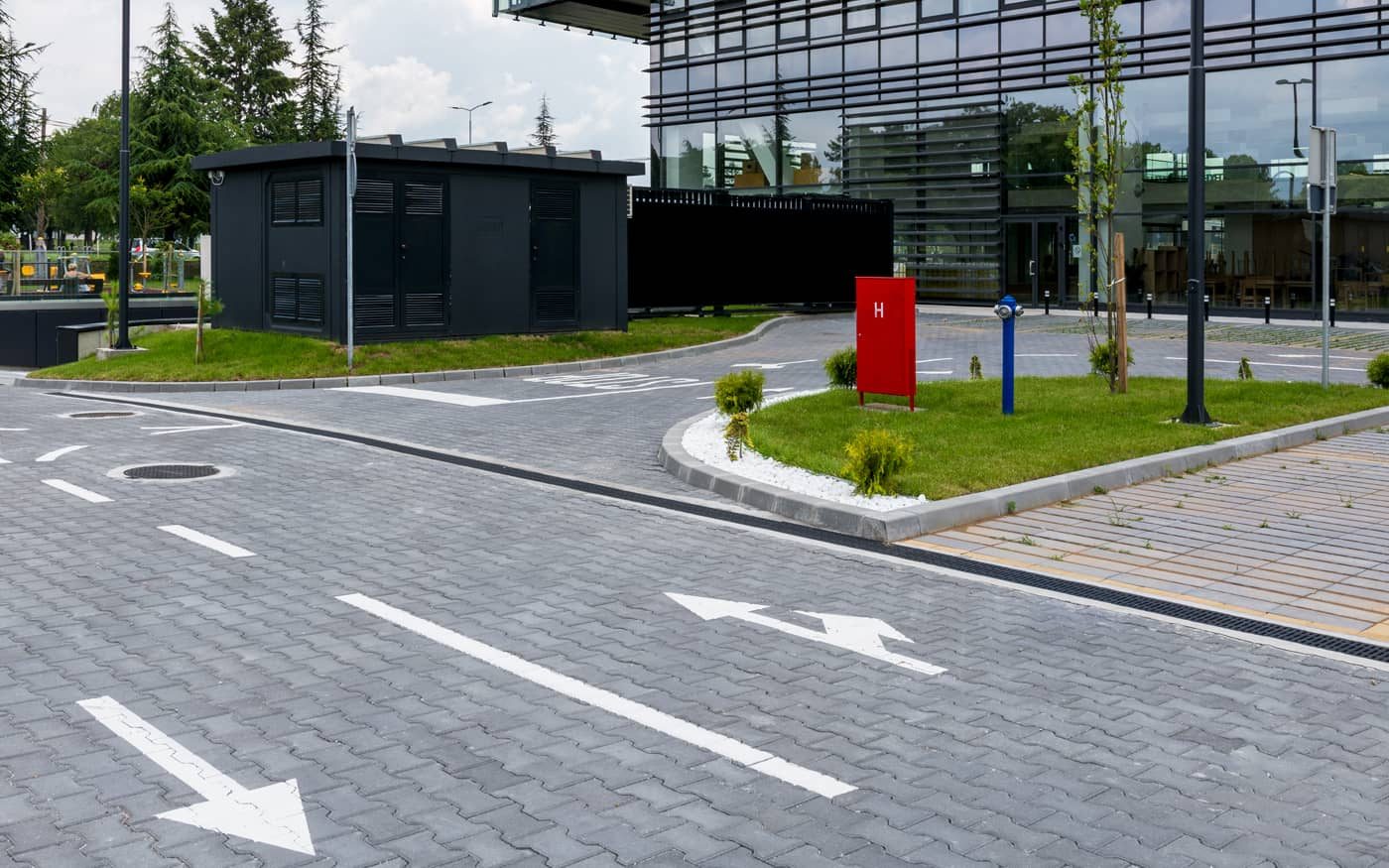 Saobraćajnica u poslovnom kompleksu sa oznakama na kolovozu popločana sivim behaton pločama, model Duplo T