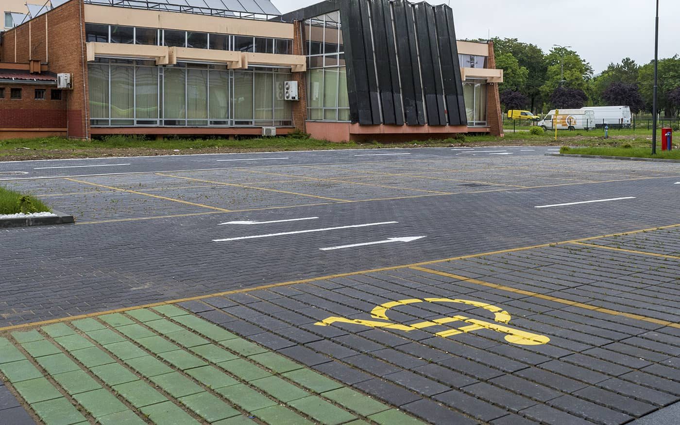 Parking ispred poslovne zgrade sa mestom za osobe sa invaliditetom, tamno sive ploče, model Domino Grass