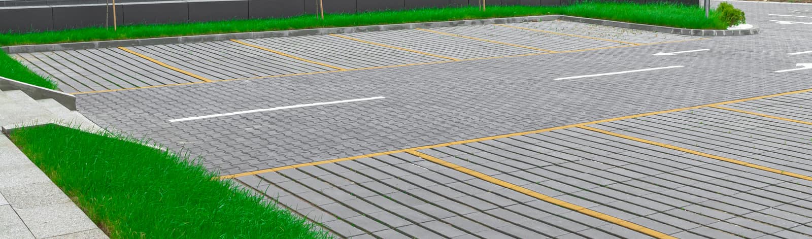 Parkiralište sa obeleženim mestima popločano sivim behaton pločama, model Domino Grass