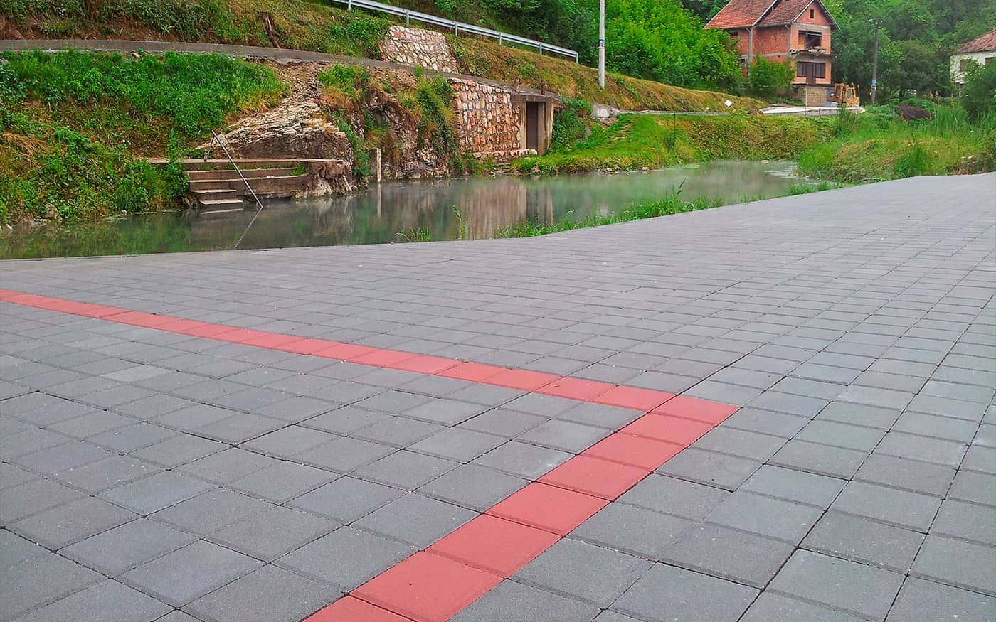 Plato uz vodu popločan sivim behaton pločama 20x20 sa crvenom trakom, model Holand 20x20