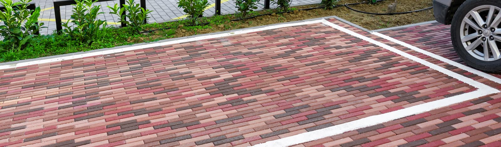 Parking mesto popločano crveno-braon behaton pločama sa belim obeležavanjem, model Holandese