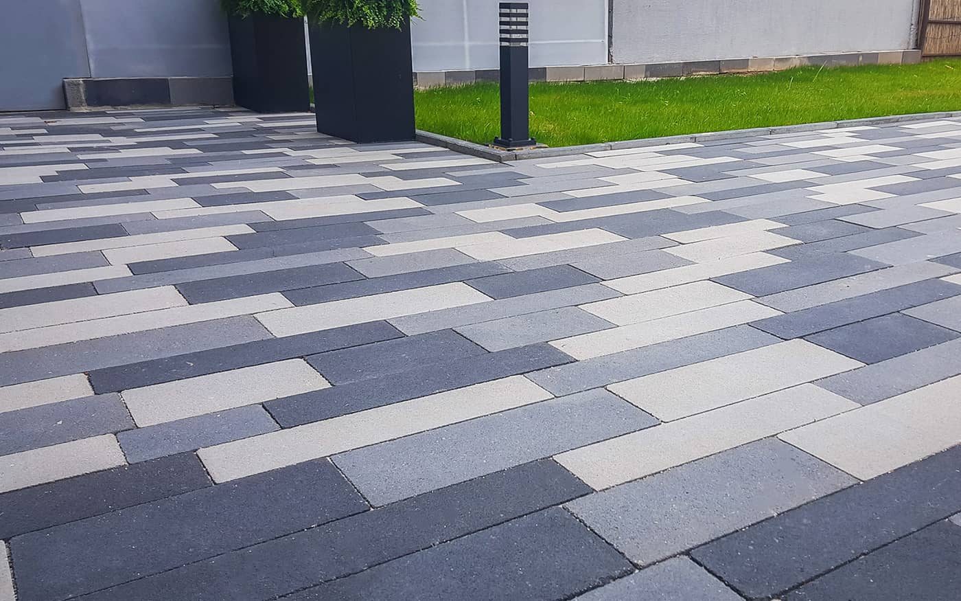 Dvorište uz travnjak popločano izduženim behaton pločama u svetlo i tamno sivoj boji, model Linea
